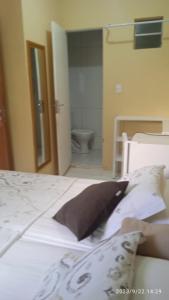 a bedroom with a bed and a bathroom with a toilet at Hospedaria FOR755 in Fortaleza