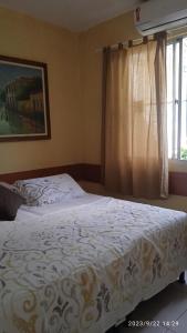 um quarto com uma cama branca e uma janela em Hospedaria FOR755 em Fortaleza