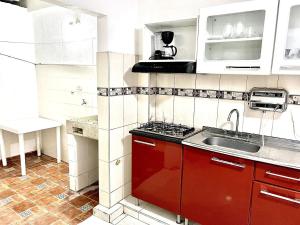 a kitchen with red cabinets and a sink at Apartamento Cerca al Complejo Deportivo in Valledupar