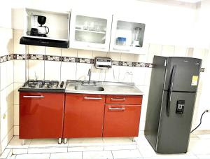 a kitchen with red cabinets and a stainless steel refrigerator at Apartamento Cerca al Complejo Deportivo in Valledupar