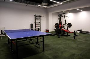 ein Zimmer mit einer Tischtennisplatte und einem Fitnessraum in der Unterkunft Apartament PrzystańTu Relax&Spa in Dziwnów