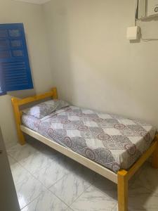 a small bed in a corner of a room at Porto Colore praça Sete in Porto De Galinhas