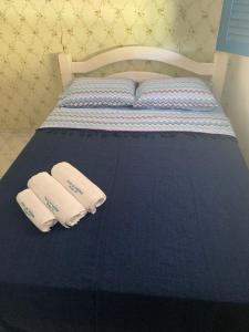 a bed with two white towels on top of it at Porto Colore praça Sete in Porto De Galinhas