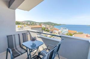 a balcony with a table and chairs and the ocean at Apartments Katic in Ražanj