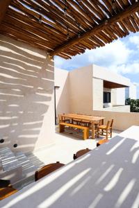a patio with a wooden table and benches on a roof at Akbal Tulum in Tulum