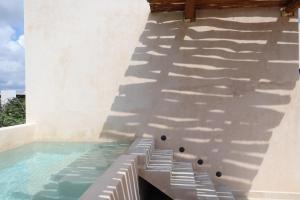 a swimming pool with a shadow on the side of a building at Akbal Tulum in Tulum