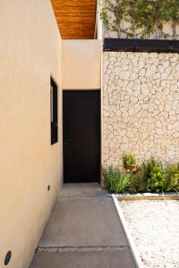 a garage with a black door and a stone wall at Akbal Tulum in Tulum