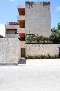 a building with a stone wall next to a sidewalk at Akbal Tulum in Tulum