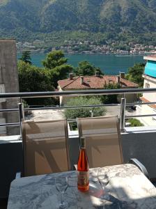 uma garrafa de vinho sentada numa mesa com duas cadeiras em M&M Apartment em Kotor