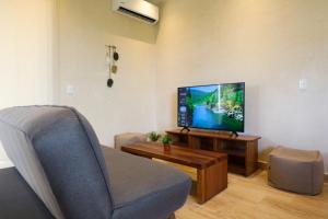 a living room with a tv and a couch and a chair at Akbal Tulum in Tulum