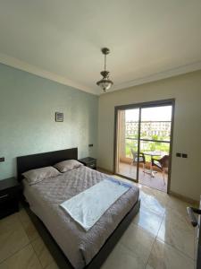 una camera con letto e porta scorrevole in vetro di Appartement en résidence privée a Marrakech