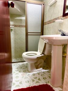 uma casa de banho com um WC, um lavatório e um chuveiro em H-OSTELLO LA MERIDIANA em Villa de Leyva