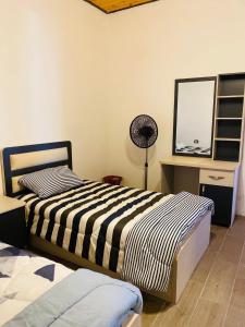 a bedroom with two beds and a desk with a mirror at Souf view in Jerash