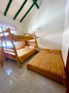 a bedroom with two bunk beds in a room at H-OSTELLO LA MERIDIANA in Villa de Leyva
