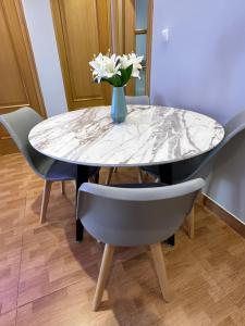 a dining room table with a vase of flowers on it at Apartamento Zaragoza Picarral in Zaragoza