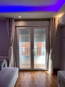 Schlafzimmer mit einer großen Glasschiebetür in der Unterkunft Apartamento Zaragoza Picarral in Saragossa