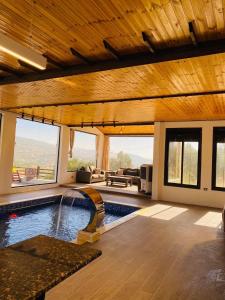 a swimming pool in a house with a large ceiling at Souf view in Jerash