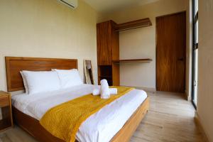 a bedroom with a bed with a stuffed animal on it at Akbal Tulum in Tulum
