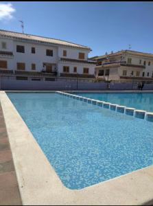 une grande piscine en face d'un bâtiment dans l'établissement RELAX en SANTA POLA, ALICANTE, à Santa Pola