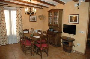 Casa Rural Nuri de Rei A y B في Todolella: غرفة طعام مع طاولة وتلفزيون