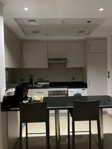 uma cozinha com um balcão preto e cadeiras em Cozy Suite with Sky view em Riyadh