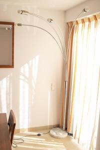 a floor lamp in a living room next to a window at Happy Tavira Apartments - Apartamento Inspire Cabanas no Resort Golden Club in Cabanas de Tavira