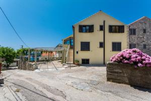 a house with pink flowers in front of it at Apartments Šiljug in Cavtat