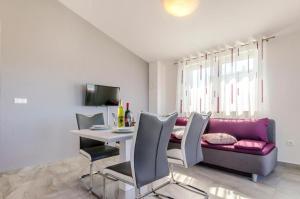 a living room with a table and a purple couch at Apartments Katic in Ražanj