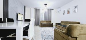 sala de estar con mesa blanca y sofá en New Bazaar Side Bliss 2 Bed Room apt with free garage en Tirana