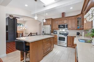 cocina grande con armarios de madera y encimera en Luxr's Lodge, en Surrey