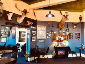 a restaurant with a fireplace and tables and antlers on the wall at COMMERCIAL HOTEL KANIVA in Kaniva