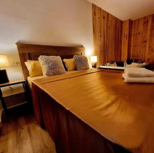 a bedroom with a large bed with a wooden headboard at Vivienda Plaza Mayor in León