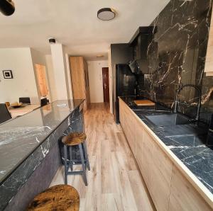 a kitchen with a counter with a sink and a stool at Vivienda Plaza Mayor in León