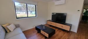 a living room with a couch and a flat screen tv at Wedderburn Caravan Park in Wedderburn