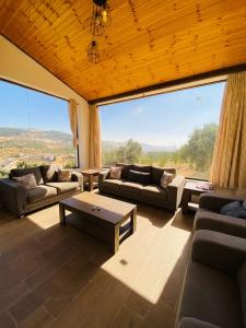 a large living room with couches and a large window at Souf view in Jerash