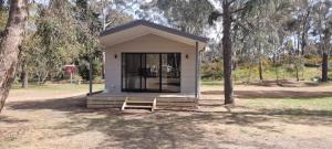 a small shed with a bench in a park at Wedderburn Caravan Park in Wedderburn