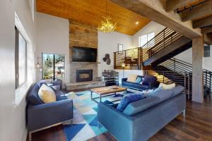 a living room with two blue couches and a fireplace at Tahoe Tyrol Chalet in South Lake Tahoe