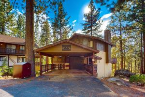 a large house with a driveway in the woods at Tahoe Tyrol Chalet in South Lake Tahoe
