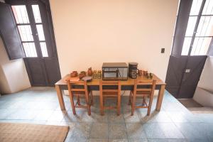 a wooden table with chairs and a microwave on it at Casa Sofi Oaxaca in Oaxaca City
