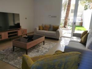 sala de estar con sofás y TV de pantalla plana. en فيلا مسقط - Muscat Villa en Bawshar