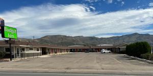 a empty parking lot in a small town with mountains at Budget Inn in Alamogordo