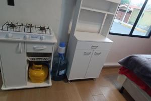 a kitchen with a stove and a white refrigerator at Suite Estudio 2 Buena Vista Santa Tecla in Nueva San Salvador