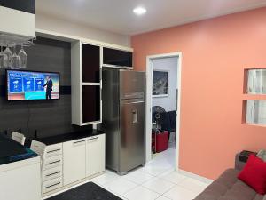 uma cozinha com um frigorífico e uma televisão na parede em Fioravante's Apartment 2 no Rio de Janeiro