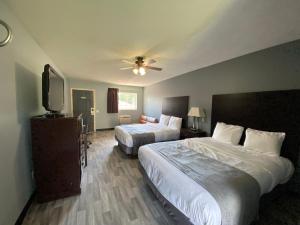 BerryvilleにあるAya's Blossoms Innのベッド2台と薄型テレビ付きのホテルの部屋