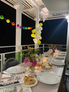 einen langen Tisch mit Teller mit Essen und Blumen darauf in der Unterkunft Gonadze Vineyards Hotel in Ambrolauri