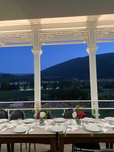 a dining room with a table and chairs with a view at Gonadze Vineyards Hotel in Ambrolauri