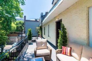 a patio with a couch and chairs on a balcony at MTL Artist Loft - Champs in Montréal