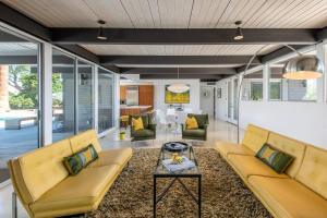 a living room with yellow couches and a table at The Milky Way Modern Desert Retreat in Borrego Springs