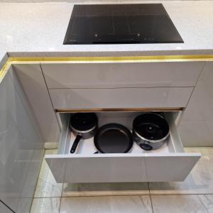 un tiroir dans une cuisine avec trois casseroles et des poêles dans l'établissement Delightful & Spacious Guest House in Farnworth Near Bolton Hospital, à Farnworth 12 autres photos