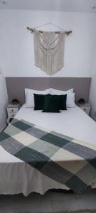 ein Schlafzimmer mit einem großen weißen Bett mit grünen Kissen in der Unterkunft Residencial suíte Arraial in Arraial do Cabo
